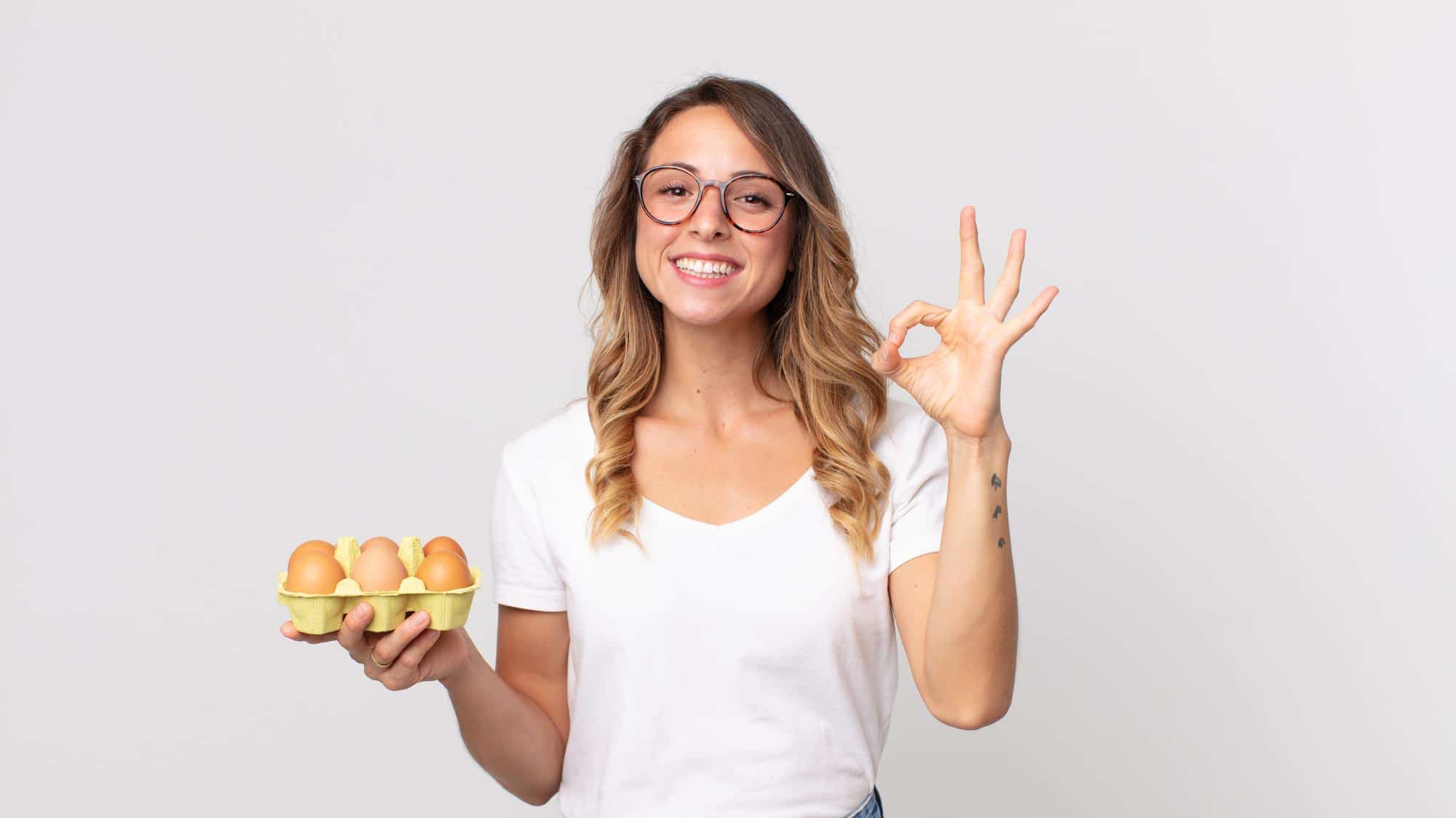 mujer con media docena de huevos