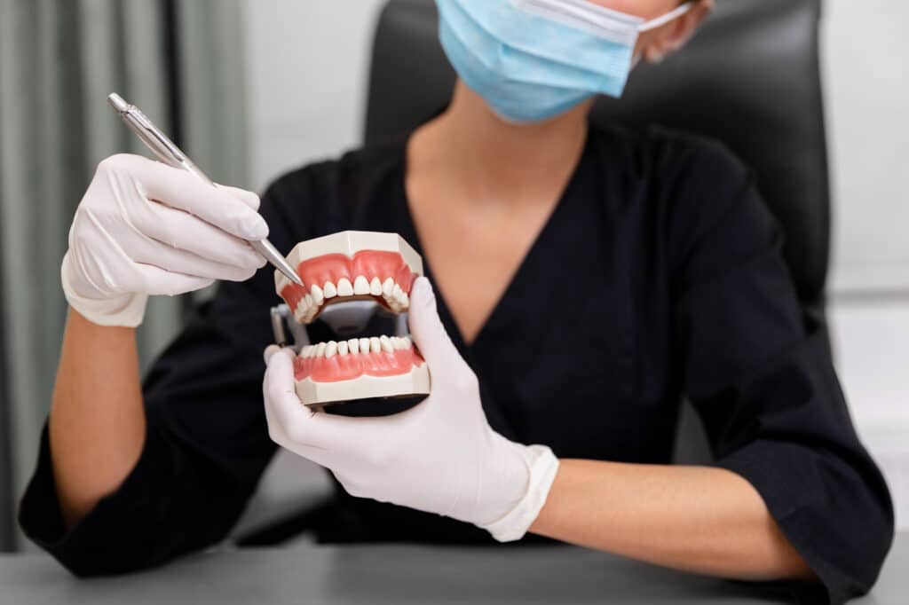 Dentista enseñando dentadura con implantes